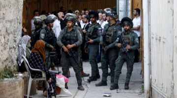 Members of Israeli forces stand guard as Israeli settlers visit community in Hebron